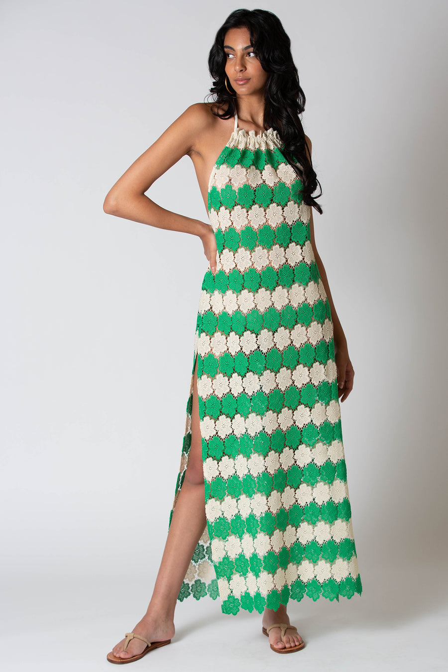 This is a photo of a woman posing in a green and ivory lace dress.