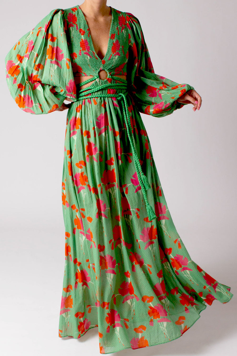 This is a photo of a woman wearing a long green dress with flowers on it.