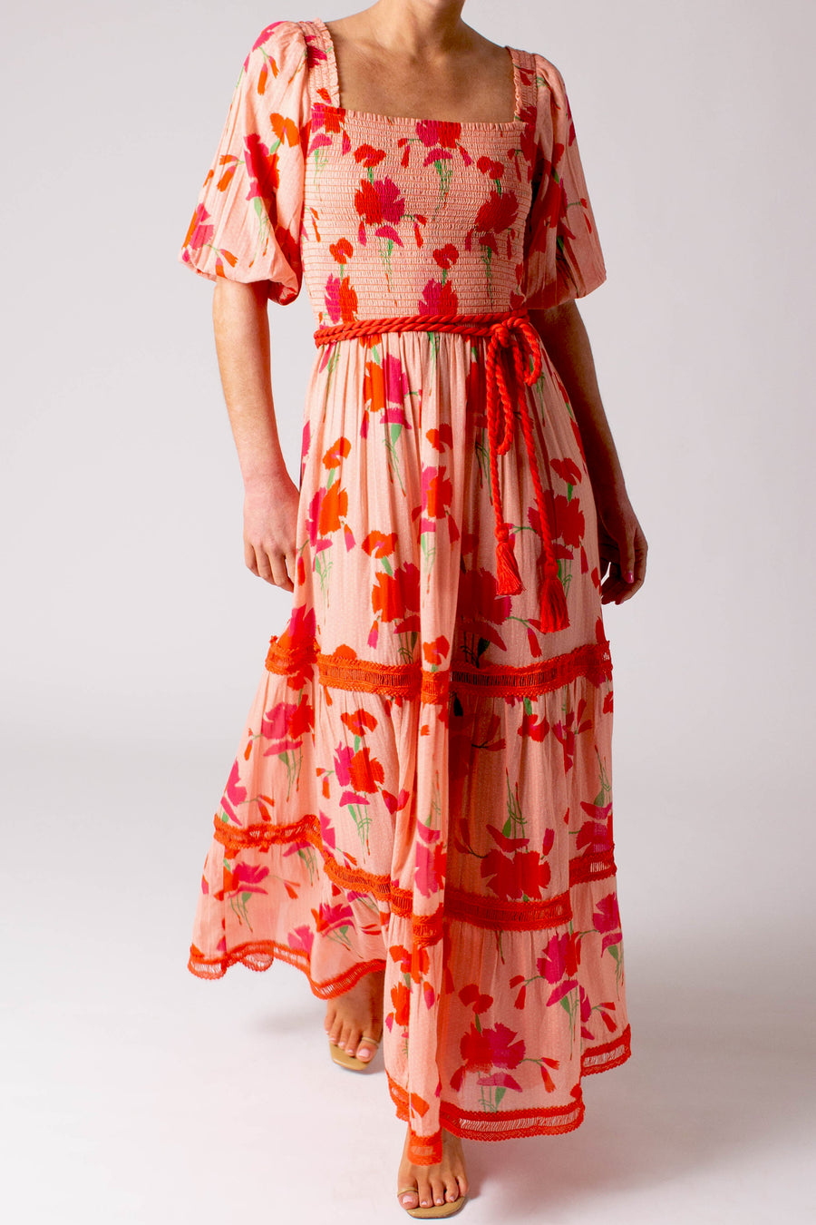 This is a photo of a woman wearing a long printed pink dress.