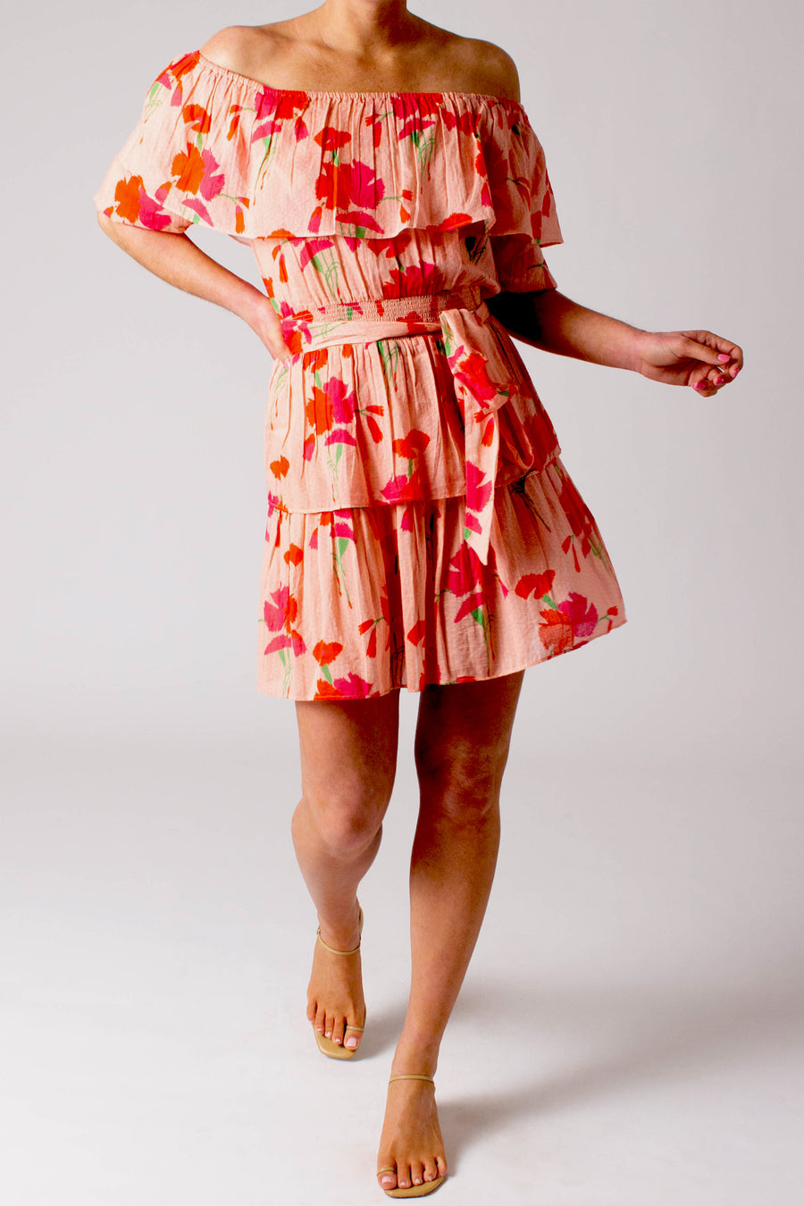 This is the photo of a woman wearing a light pink floral dress. The dress is short and flowy.