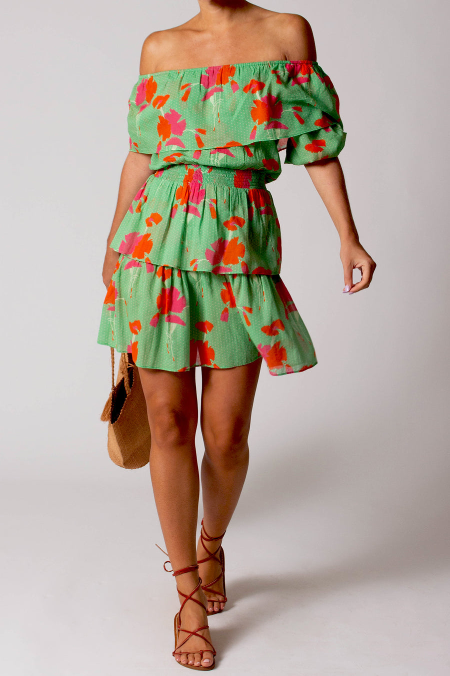 This is the photo of a woman wearing a green dress with a pink and orange floral pattern.