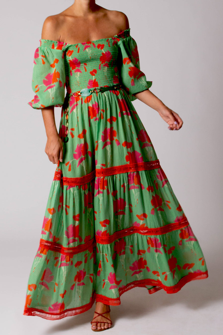 This is a photo of a woman wearing a green printed long dress.