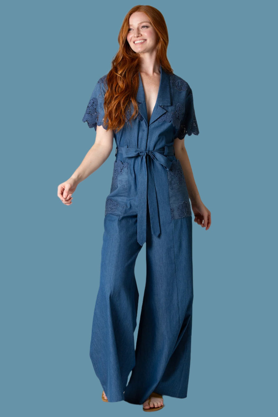 This is a photo of a model posing in a indigo denim jumpsuit.
