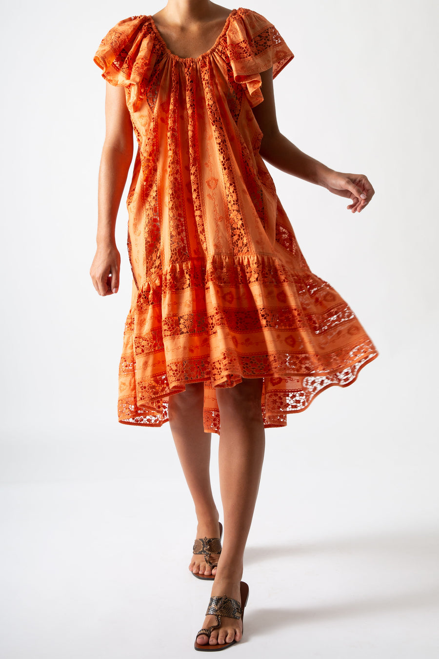 This is a photo of a woman wearing an orange cover up.