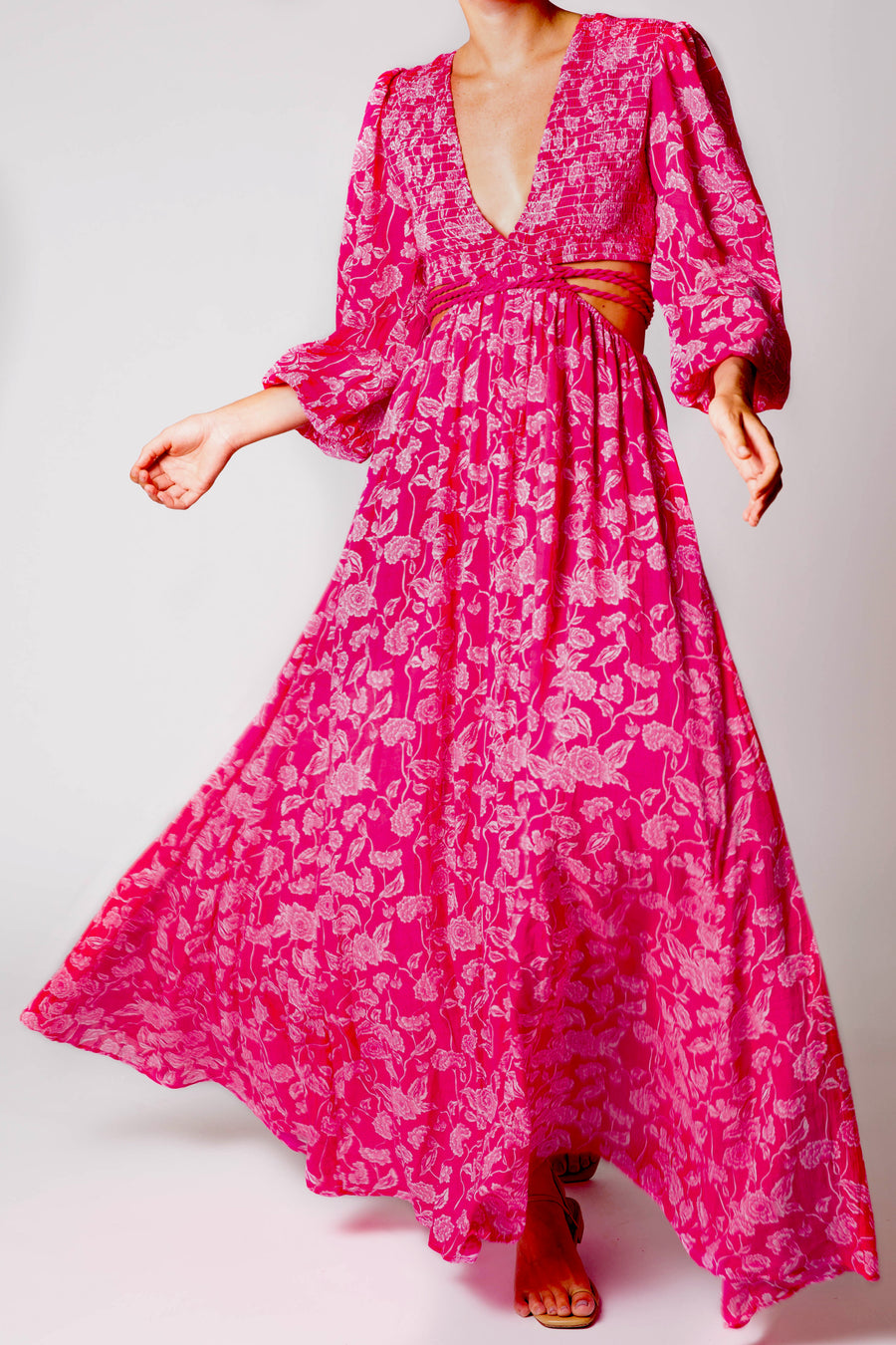 This is a photo of a woman wearing a flowy pink maxi dress.
