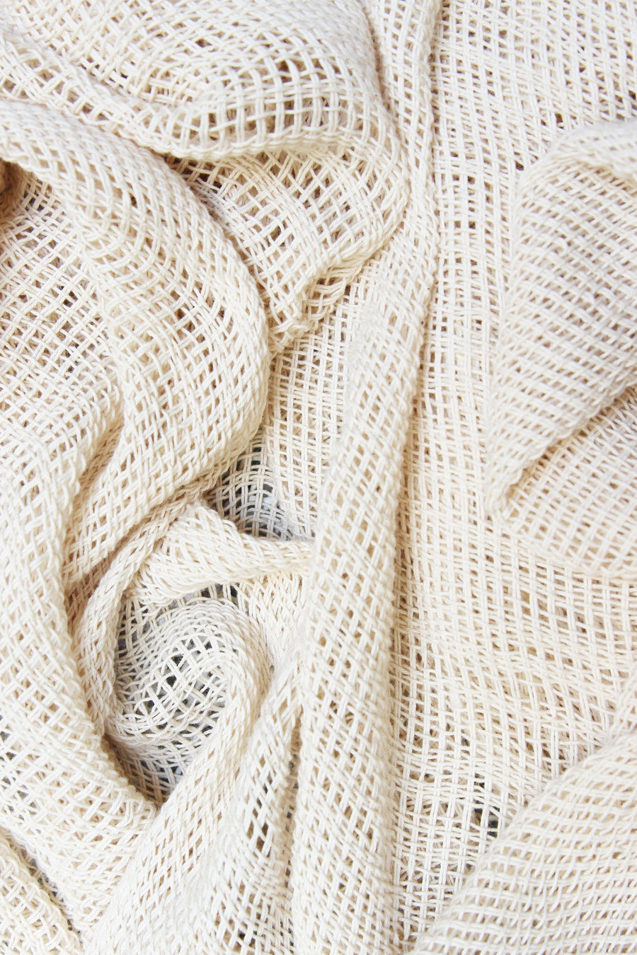 This is a detail photo of the texture of a handmade knit natural-colored shawl.