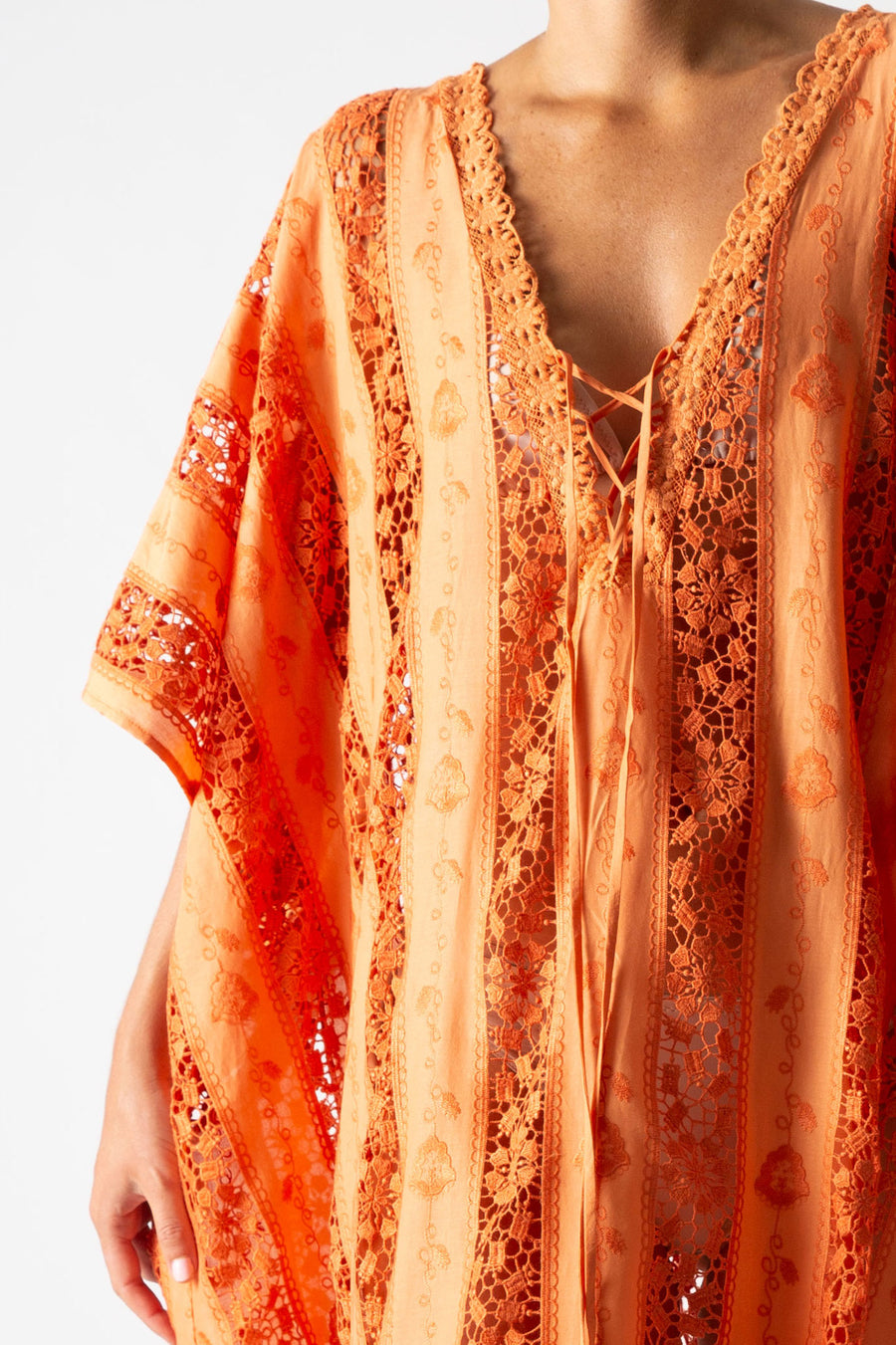 This is a detailed photo of an orange cover up with moonshine embroidery.