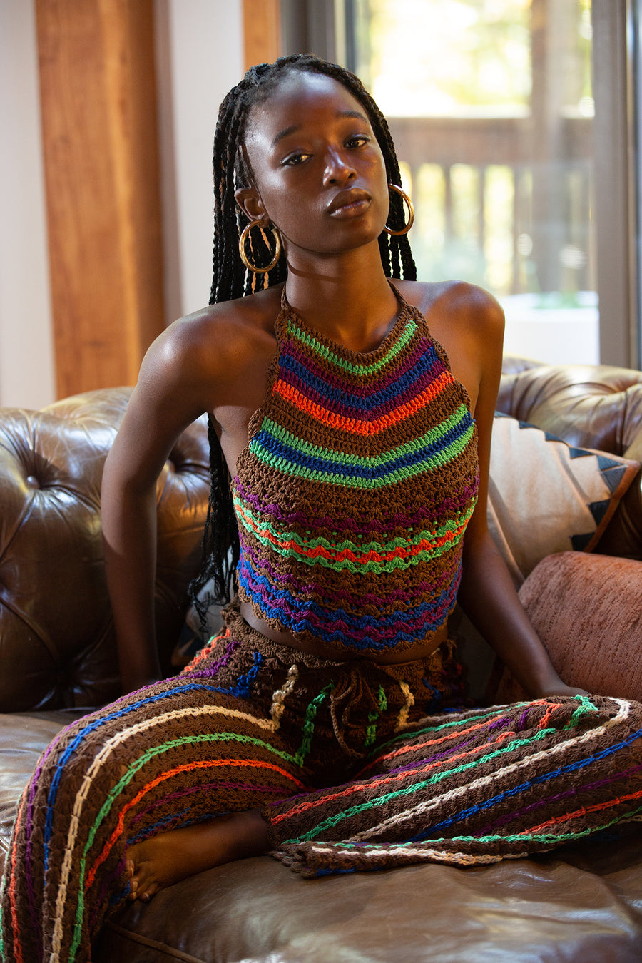 This is a photo of a woman wearing a colorful, high neck, knit crop top.